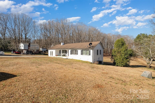 view of front of house with central AC unit and a front lawn