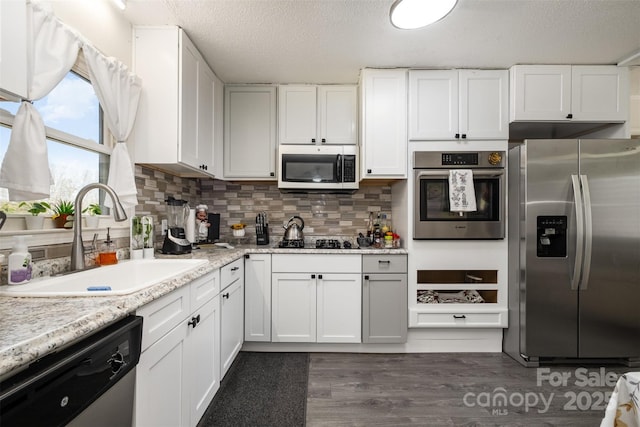 kitchen featuring appliances with stainless steel finishes, sink, and white cabinets