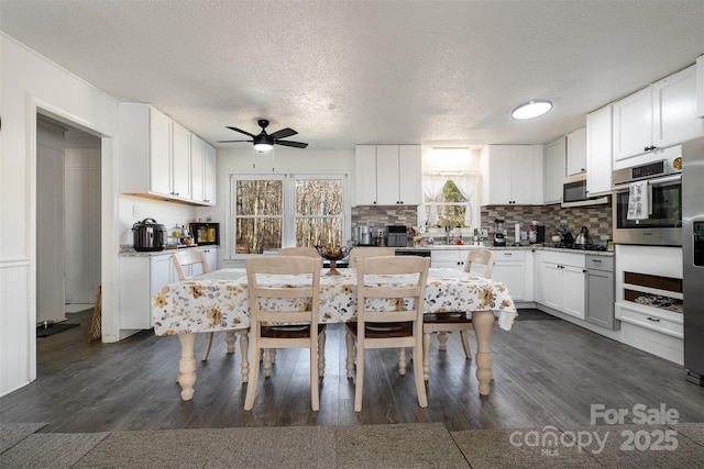 kitchen featuring decorative backsplash, dark wood-type flooring, and white cabinets