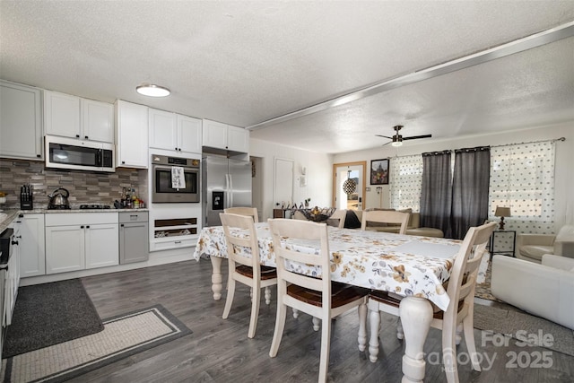 dining space featuring ceiling fan, dark hardwood / wood-style floors, and a textured ceiling