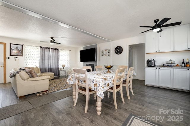 dining room featuring dark hardwood / wood-style floors, a textured ceiling, and ceiling fan