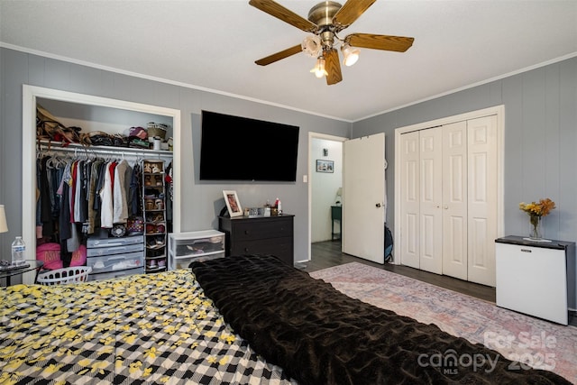 bedroom with crown molding, dark wood-type flooring, ceiling fan, and a closet