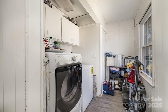 laundry room with light hardwood / wood-style floors, cabinets, and washing machine and clothes dryer