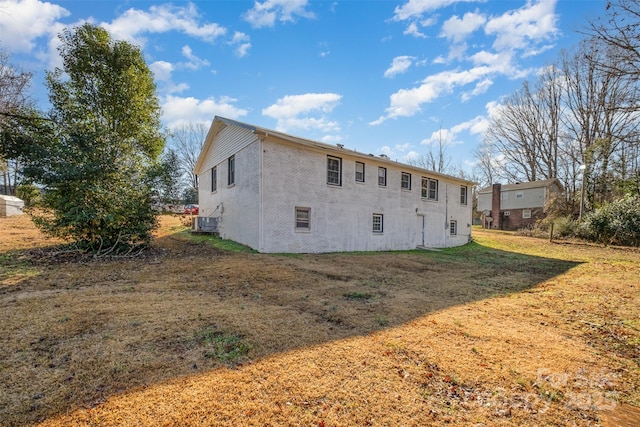 back of property with a yard and central AC unit