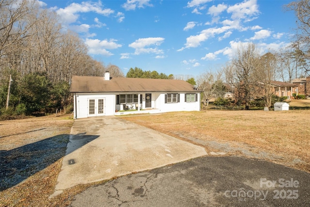 single story home featuring a front lawn and french doors