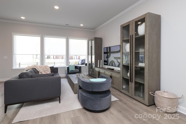 living room with crown molding and light wood-type flooring