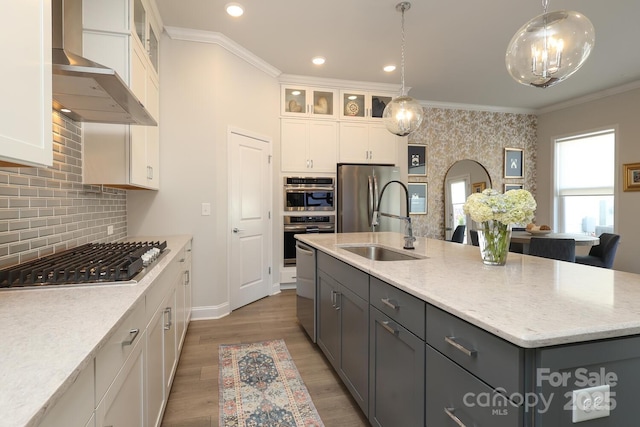 kitchen featuring gray cabinets, appliances with stainless steel finishes, white cabinetry, hanging light fixtures, and an island with sink