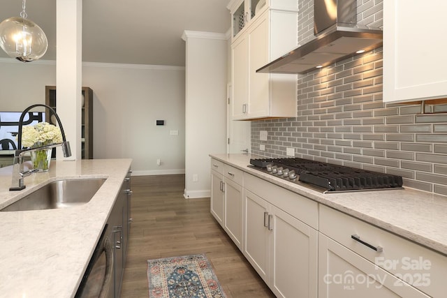 kitchen with pendant lighting, stainless steel gas stovetop, white cabinetry, light stone countertops, and wall chimney range hood