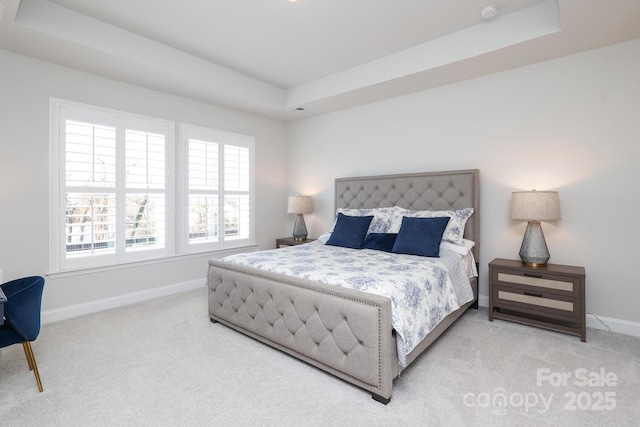 bedroom with carpet flooring and a tray ceiling