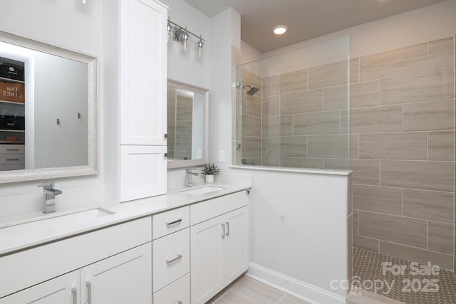 bathroom featuring tiled shower and vanity