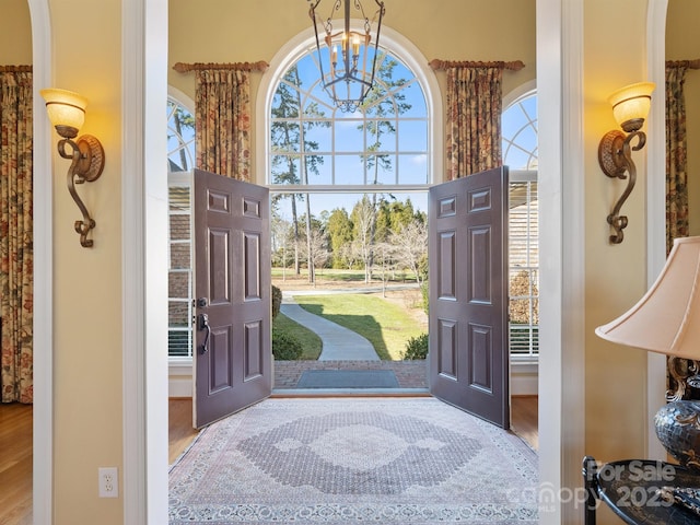 entrance foyer featuring hardwood / wood-style flooring, a high ceiling, and a notable chandelier