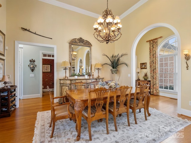 dining room featuring ornamental molding, a chandelier, and light wood-type flooring