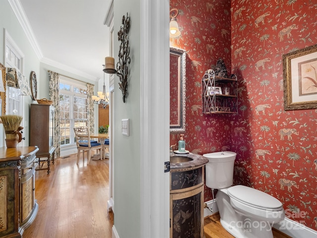 bathroom with ornamental molding, toilet, hardwood / wood-style floors, and vanity