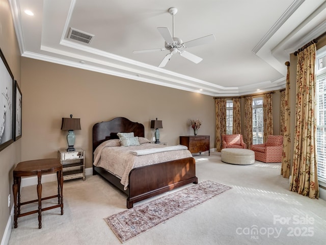 bedroom with light carpet, crown molding, a raised ceiling, and ceiling fan