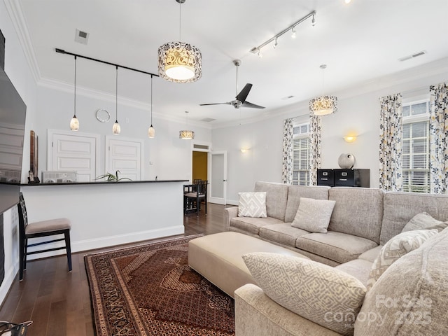 living room with ornamental molding, rail lighting, ceiling fan, and dark hardwood / wood-style flooring