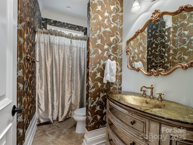 bathroom with ornamental molding, vanity, and toilet