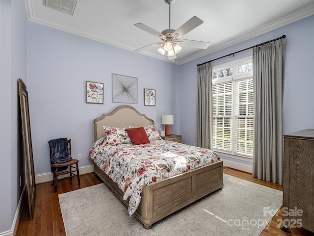 bedroom with wood-type flooring, ornamental molding, and ceiling fan