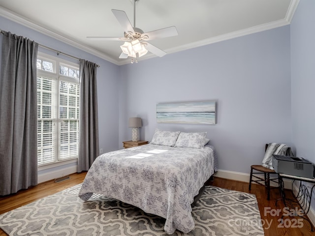 bedroom with multiple windows, crown molding, and wood-type flooring