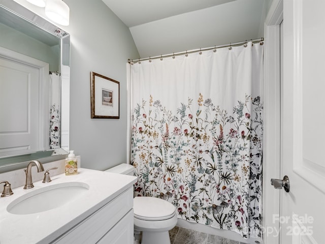 bathroom featuring lofted ceiling, vanity, and toilet