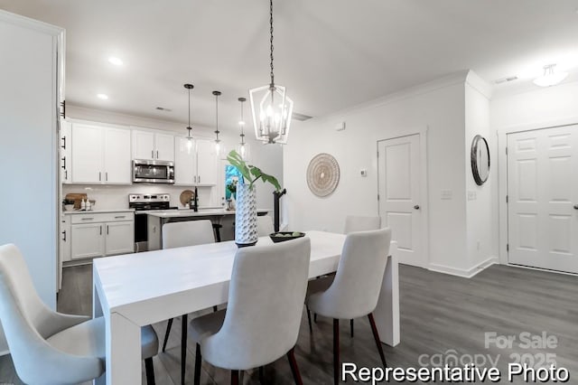 dining area featuring crown molding, dark hardwood / wood-style floors, and a notable chandelier