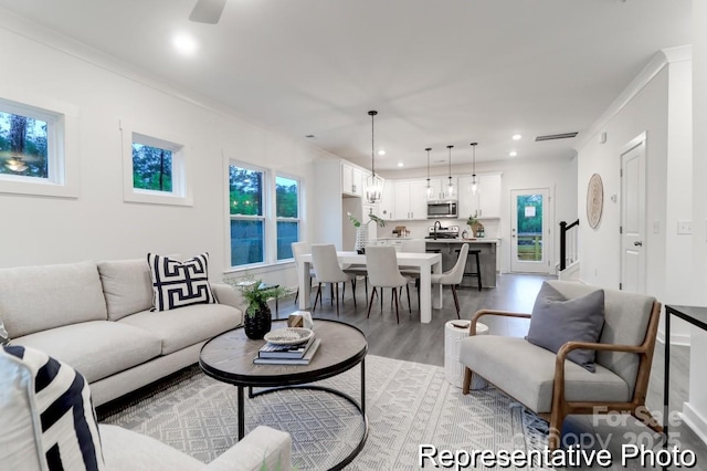 living room with ornamental molding and light hardwood / wood-style floors