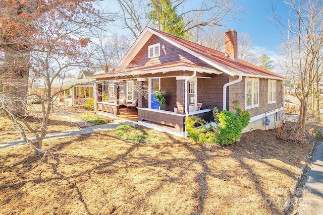 view of front of property with covered porch and a chimney