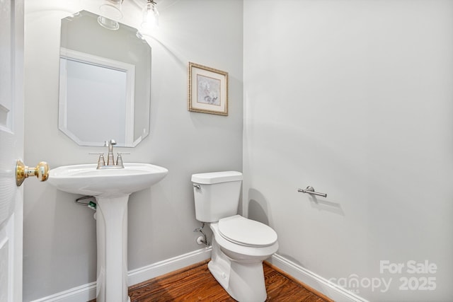 bathroom with toilet and hardwood / wood-style floors