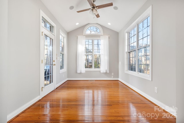 unfurnished room featuring lofted ceiling, hardwood / wood-style floors, and ceiling fan