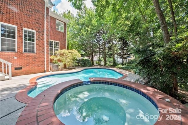 view of pool with an in ground hot tub