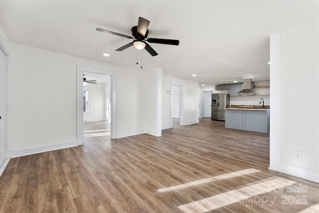 unfurnished living room with ceiling fan and light hardwood / wood-style floors