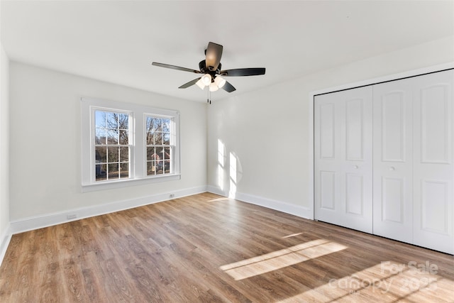 unfurnished bedroom with light hardwood / wood-style flooring, a closet, and ceiling fan