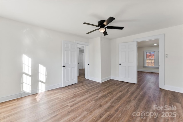 unfurnished bedroom featuring ceiling fan and dark hardwood / wood-style flooring