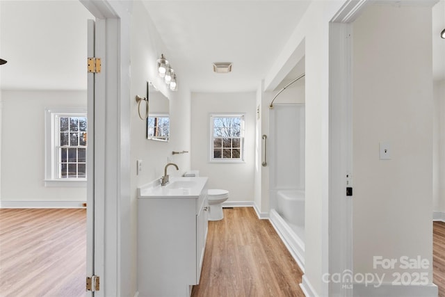 bathroom featuring vanity, wood-type flooring, walk in shower, and toilet