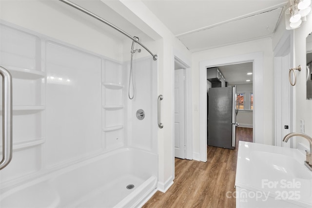 bathroom featuring walk in shower, sink, and hardwood / wood-style floors