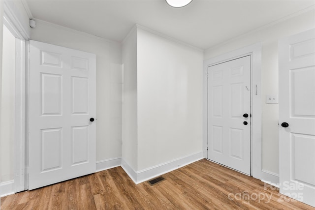 entryway featuring ornamental molding and hardwood / wood-style floors