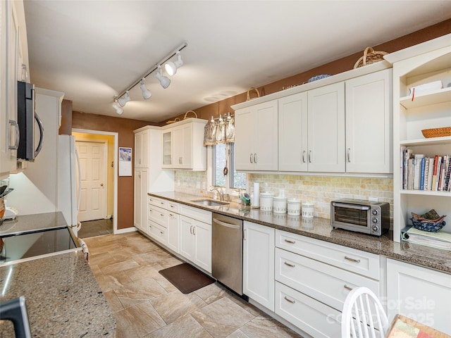 kitchen featuring stone countertops, sink, white cabinets, decorative backsplash, and stainless steel appliances