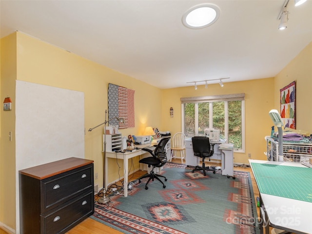 home office with track lighting and wood-type flooring