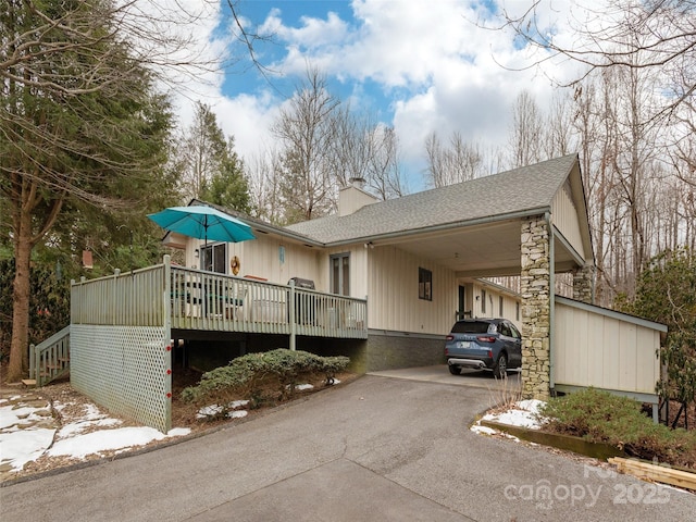 view of property exterior featuring a carport and a wooden deck