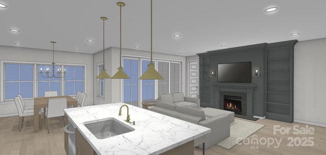 kitchen with recessed lighting, a lit fireplace, a sink, hanging light fixtures, and a notable chandelier