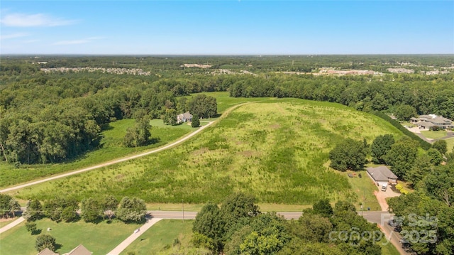 birds eye view of property featuring a forest view