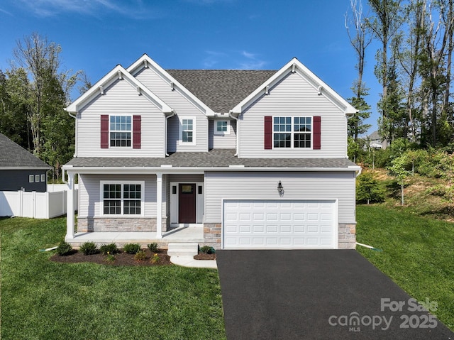 view of front of property with a garage, a porch, and a front lawn