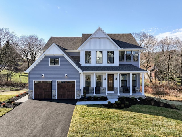 view of front of house with a garage, covered porch, and a front yard