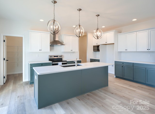 kitchen featuring sink, white cabinets, hanging light fixtures, stainless steel appliances, and a center island with sink