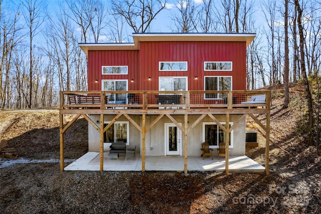 rear view of house with a wooden deck and a patio area