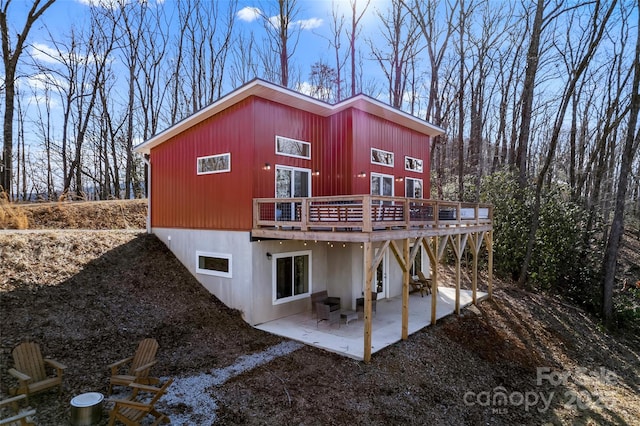 back of property with a deck and a patio area