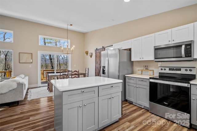 186 S Slope Ln, Old Fort, NC 28762 - kitchen featuring a notable chandelier, appliances with stainless steel finishes, wood finished floors, and gray cabinetry