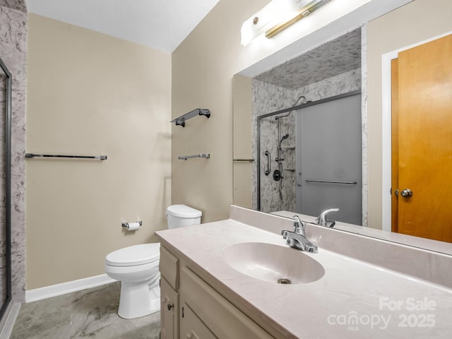 bathroom with vanity, a shower with shower door, and toilet