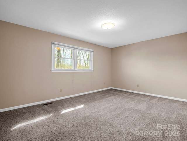 carpeted spare room with a textured ceiling