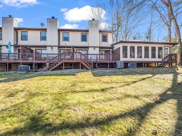 back of property with central AC unit, a lawn, a sunroom, and a deck