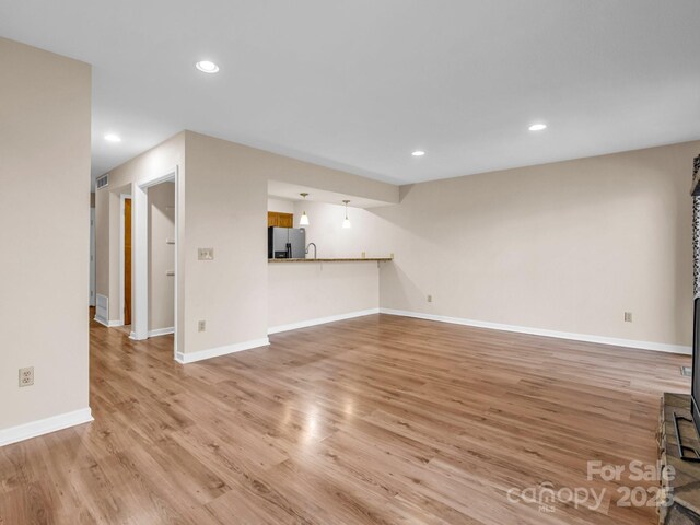 60 Vista View Ct, Etowah, NC 28729 - unfurnished living room featuring baseboards, a wood stove, recessed lighting, and wood finished floors